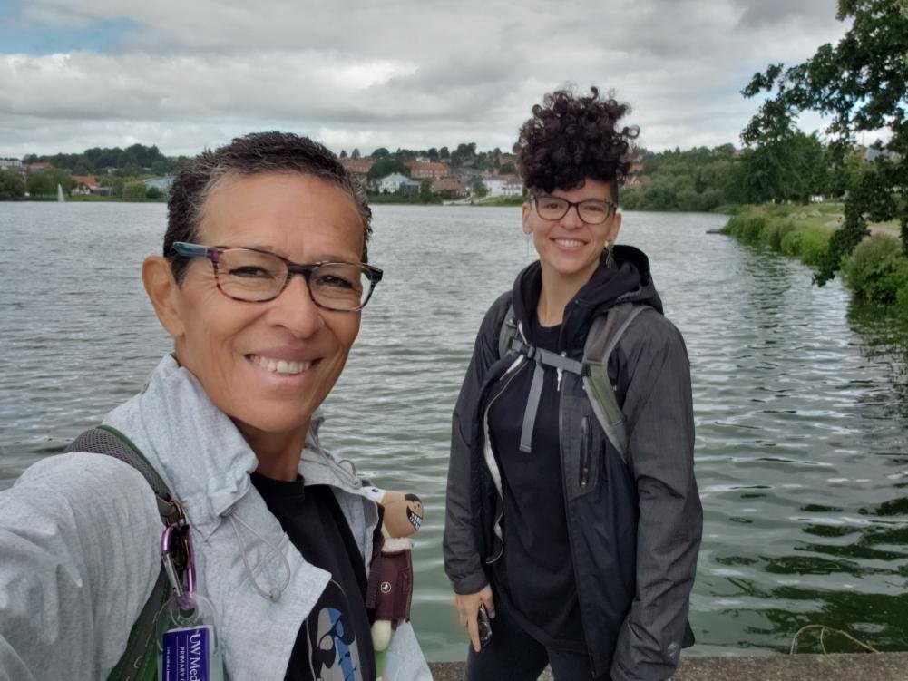 Aponwao founders Lizzie and Alejandra smiling in front of a lake.