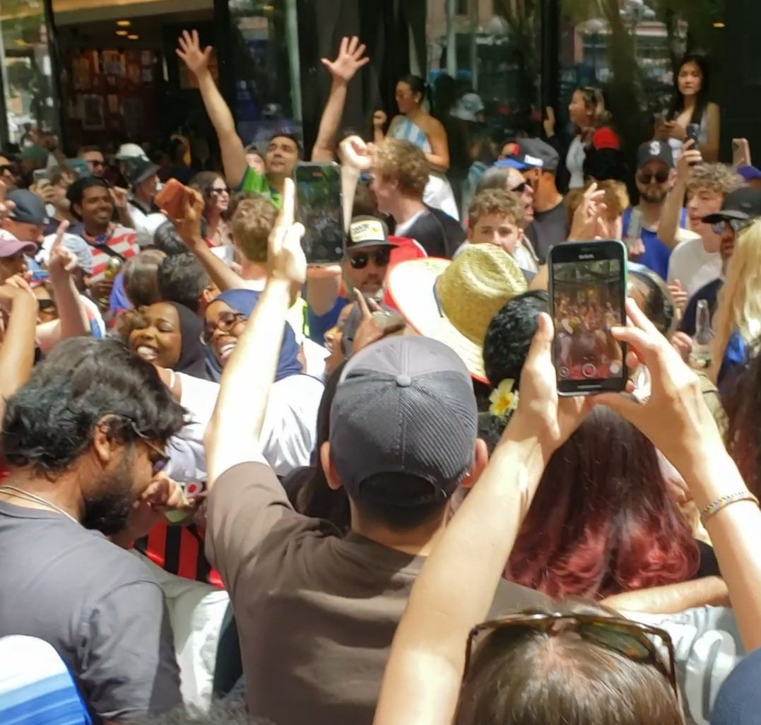 A video of a diverse crowd of people dancing together to the rhythm of Shakira's Waka Waka, capturing the joyous, shared human connection.